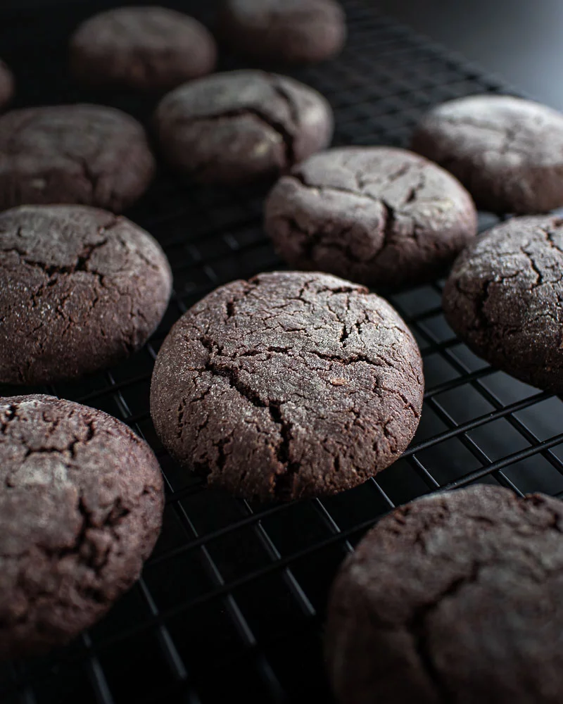 Chocolate crinkle cookies on a cooling rack, entirely vegan, made with avocado