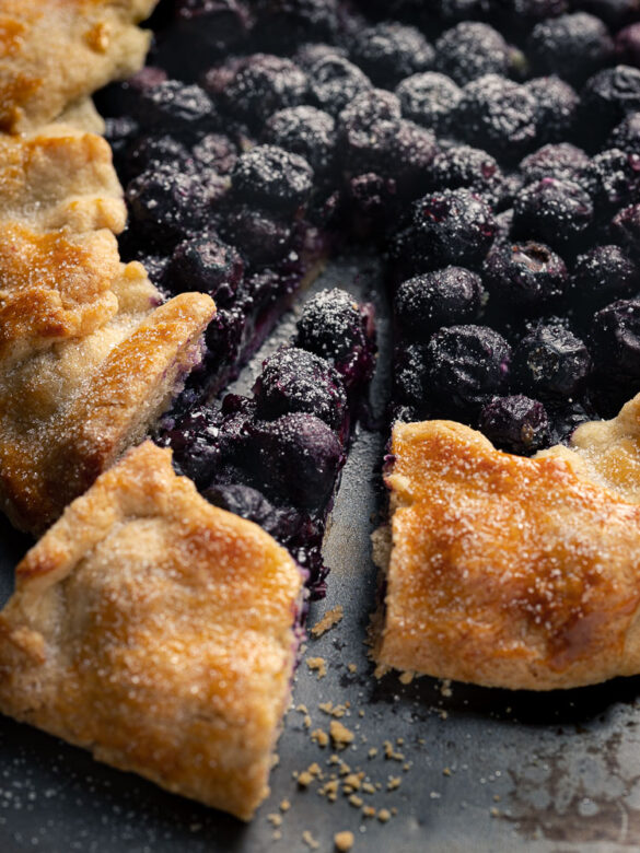 Close up of a slice of blueberry galette cut out from a whole galette