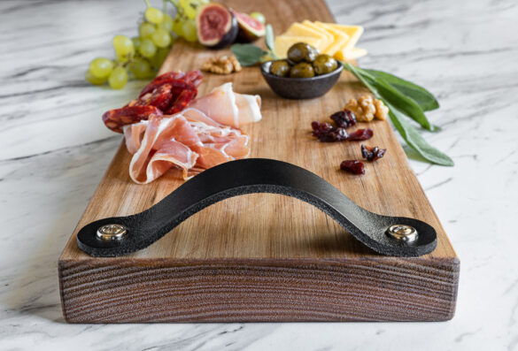 Side close up of Jemmervale Designs charcuterie board with prosciutto, olives, cheese, grapes on top