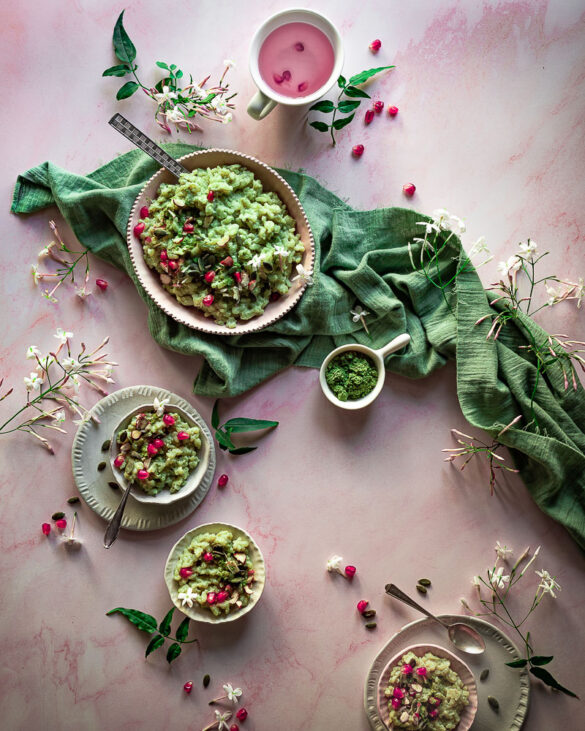 Green matcha rice pudding in various pink bows, a green napkin and red pomegranate seeds