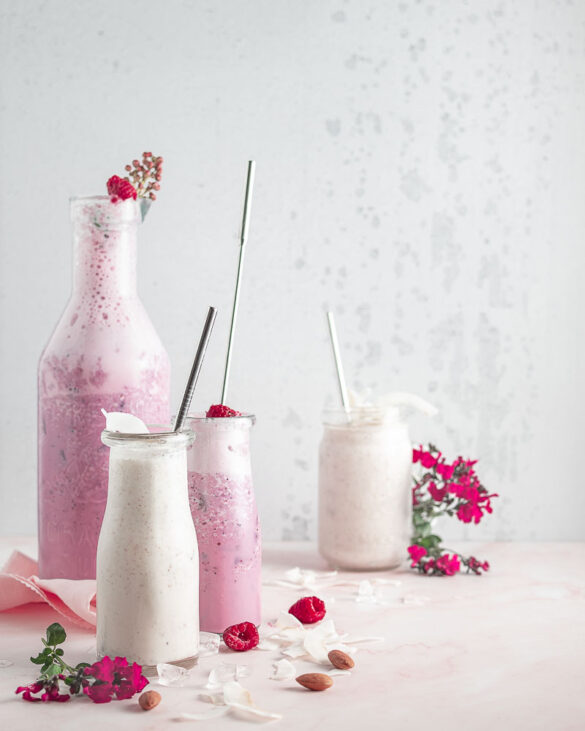 A very light scene with berry and coconut smoothies in bottles