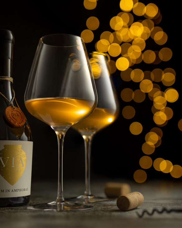 Two glasses of yellow glowing wine by Vinum in Amphorae with big yellow bokeh in the background